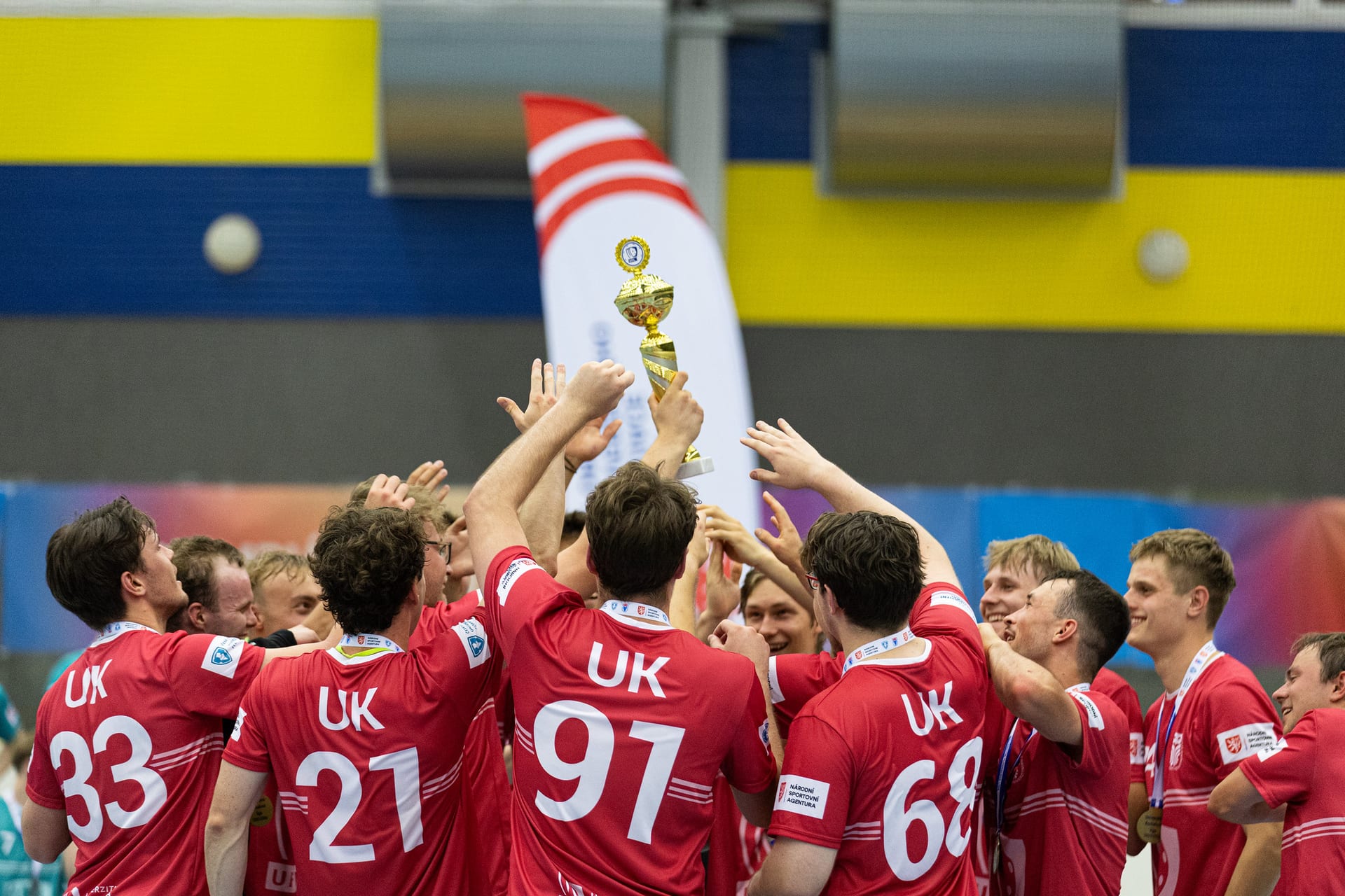 University floorball players lifting the league trophy